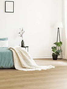 White Round Rug In Front Of Green Bed With Blanket In Bedroom Interior With Posters. Real Photo
